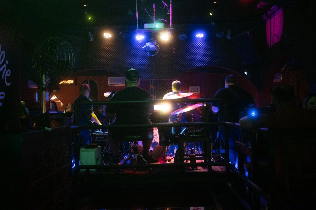 Silhueta da banda inteira sob luzes no palco